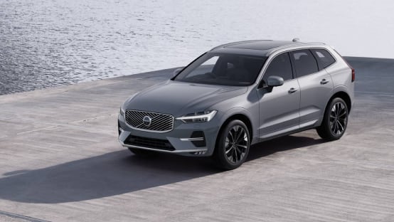 Dark grey Volvo S90 driving across a bridge.